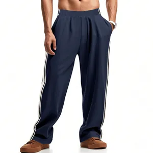 Detail van de donkerblauwe losvallende joggingbroek met witte zijstrepen voor heren