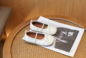 Detailed shot of elegant white children's princess shoes with a delicate bow design