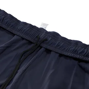Detailopname van donkerblauwe joggingbroek met elastische tailleband en verstelbaar koord