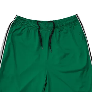 Detail van groene herenjoggingbroek met elastische tailleband en zwart trekkoord.