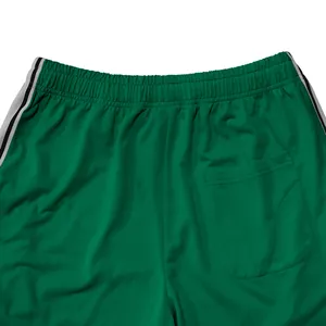 Detail van groene sportjoggingbroek met elastische tailleband en achterzak.