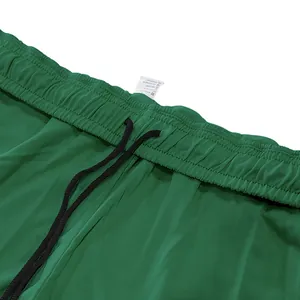 Detailopname van groene joggingbroek met elastische tailleband en zwart trekkoord