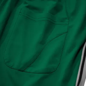 Detail van de stiksels en textuur van de achterzak op groene sportjoggingbroeken