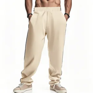 Detail van beige heren joggingbroek met zwarte zijstrepen en een losse, comfortabele pasvorm
