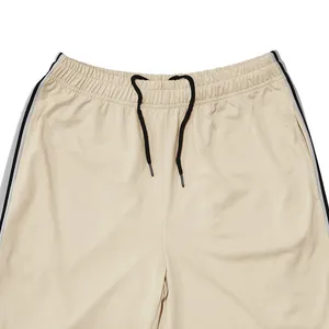 Detail van de elastische tailleband en het zwarte trekkoord op de beige sportbroek voor heren