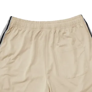Detail van de elastische tailleband en achterzak van beige sport-joggingbroeken