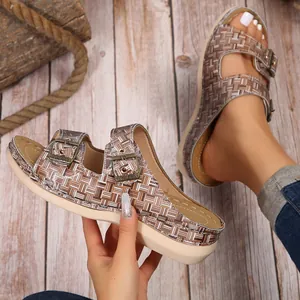 Nahaufnahme von gewebten Damen-Keilsandalen mit bronzefarbenen Metallschnallen-Details.