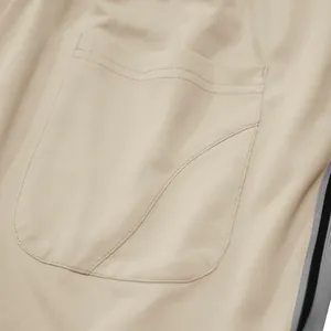 Detailopname van zak en stoftextuur van beige sportieve joggingbroeken voor heren
