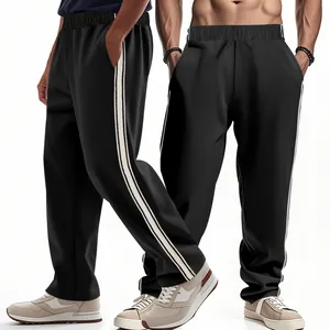 Gedetailleerde close-up van zwarte heren joggingbroek met sportieve zijstrepen en losse pasvorm.