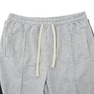 Detailopname van grijze heren joggingbroek met elastische tailleband en trekkoordjes
