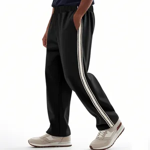 Zijaanzicht detail van de losse zwarte heren joggingbroek met witte zijstrepen