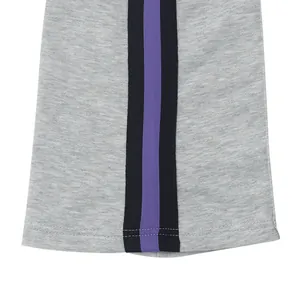 Detailopname van een grijze herensportbroek met zwart-paarse decoratieve zijstreep detail