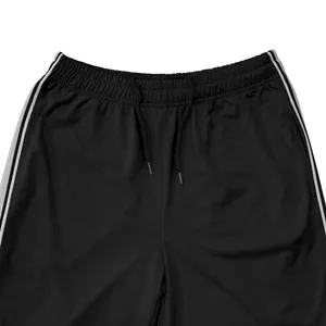 Macrodetail van de sportjoggingbroek voor heren met elastische taille, trekkoord en zijstrepen