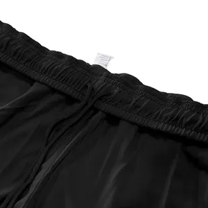 Detail van de elastische tailleband en het waslabel van de zwarte herenjoggingbroek