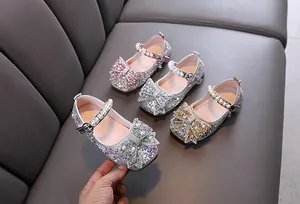 Detalle de zapatos de princesa para niña con pedrería brillante y lazos