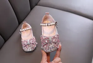 Primer plano de zapatos de princesa rosa para niñas con pedrería y perlas