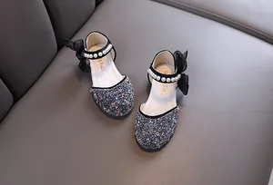 Detailansicht von Mädchen-Prinzessin-Schuhen mit Glitzer und Perlenriemen