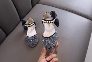 Detailansicht der glitzernden silbernen Prinzessinnenschuhe für Mädchen mit Perlenriemen