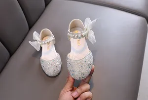 Nahaufnahme weißer Prinzessinnenschuhe für Mädchen mit glitzernden Strasssteinen und Perlen
