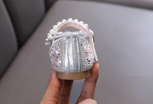 Vista detallada del zapato de princesa plateado para niñas con perlas y lentejuelas