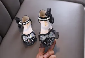 Close-up of black girl's princess shoe with sparkling rhinestones and pearl strap