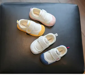 Multiple color options of soft-sole indoor baby shoes displayed on a black leather seat.