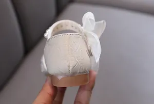 Detailansicht der Ferse und der eleganten weißen Schleife am Mädchen-Prinzessin-Schuh.