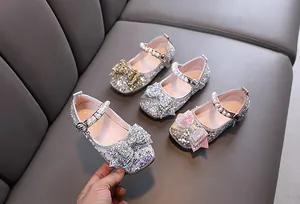 Close-up view of sparkling girls' Mary Jane shoes with rhinestones, sequins and pearls