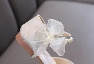 Detailansicht eleganter Mädchen-Prinzessinenschuh mit Netzschleife und Perlendetails