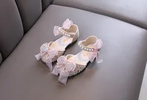 Detail of silver glitter girls princess shoes with pink tulle bows and pearl straps