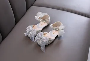 Detailed view of sparkly silver girls princess shoes featuring rhinestone bow and pearls