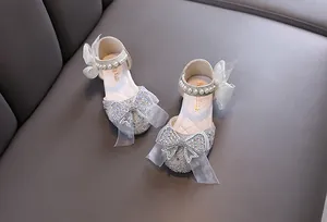 Elegant girl's princess shoes with sparkling rhinestones and pearl straps detail view