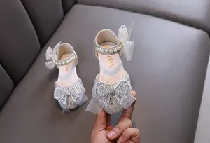 Close-up of sparkly girl's princess shoes with rhinestone bow and pearl straps