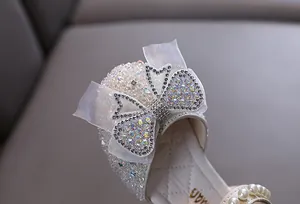 Detailed view of girls' princess shoes with rhinestones, mesh bow, and pearls