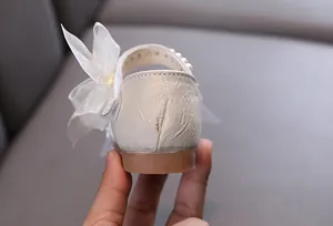 Detailed macro view of elegant pearl and organza bow on girls princess dance shoes