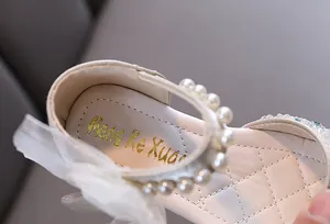 Detail view of girl's princess shoe showing pearl strap and quilted leather insole
