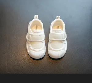 Detail view of white children's indoor shoes with breathable mesh and velcro straps