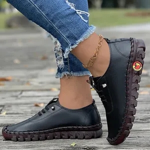 Detailed view of handmade black leather flats featuring soft soles and thick stitching