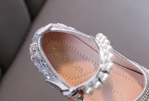 Close-up detail view of silver girls princess shoes with elegant pearls and branded insole