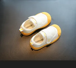 Detailed top view of white toddler indoor shoes with yellow soft soles