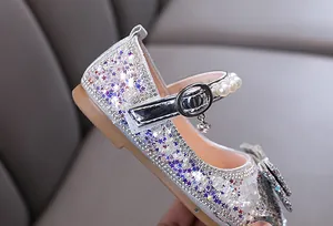 Close-up of girl's glitter princess shoe with pearls and star sequins