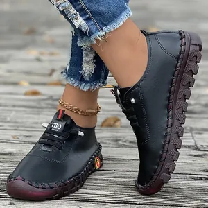 Hand-stitched soft sole black casual flat shoes for women shown in an outdoor lifestyle setting