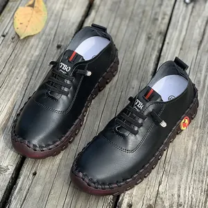 Close-up of black handmade leather mom shoes with soft tendon soles on a wooden background.
