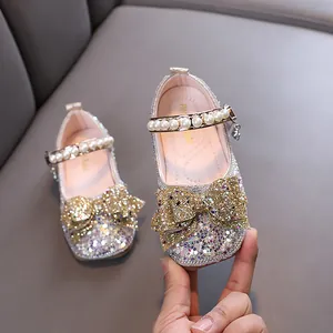 Elegant sparkling silver girls princess shoes featuring gold bow and delicate pearl strap