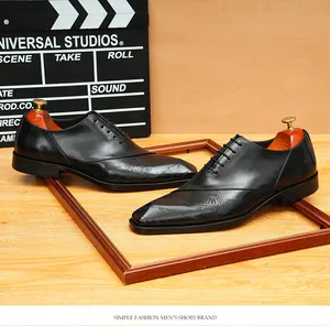 Primo piano di scarpe Oxford in pelle nera con intricati dettagli incisi sulla punta.