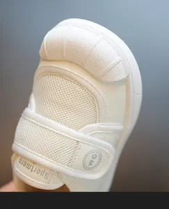Macro view of white breathable mesh toddler indoor shoe featuring a secure Velcro strap