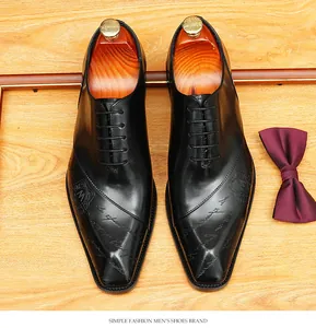Vista dall'alto di scarpe Oxford in pelle nera da uomo con scritte in rilievo e logo M inciso