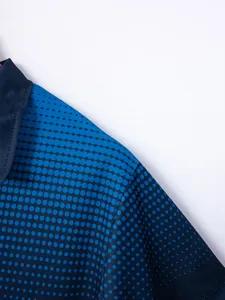 Detailed macro view of the breathable blue dot print fabric on this men's polo shirt