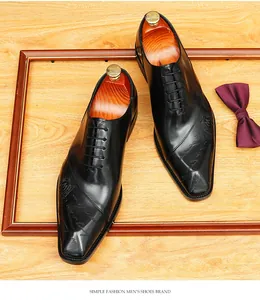 Vista ravvicinata di scarpe Oxford in pelle nera con raffinato motivo inciso sulla punta