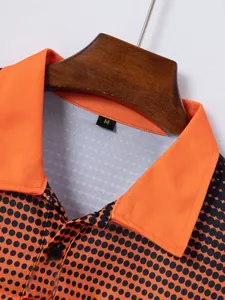 Close-up detail of men's orange casual polo shirt with black polka dots and size M tag